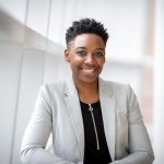 Confident African American businesswoman smiling inside a modern office space.